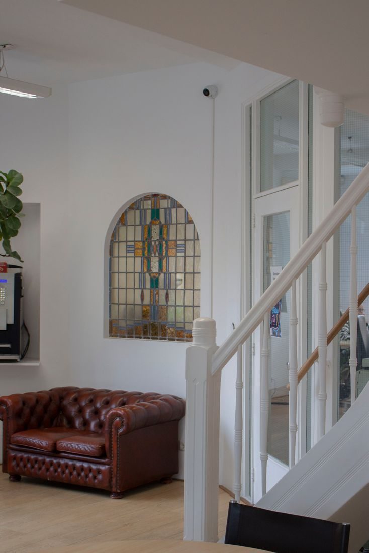 Zithoek met leren fauteuil naast de trap