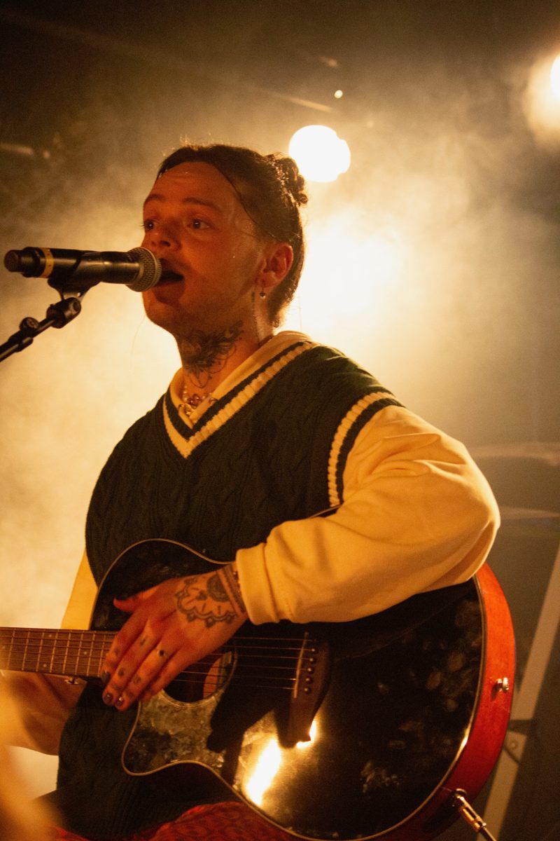 Zanger met gitaar tijdens optreden van Nobu